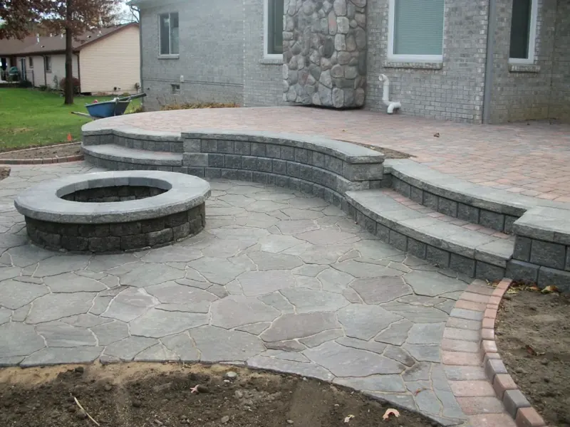 Raised paver patio with fire pit and seating wall